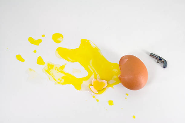 Despair and Suicide An egg commits suicide by putting a gun to its head egg yolk on white stock pictures, royalty-free photos & images