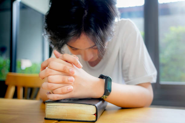 Christian Praying on open Bible.