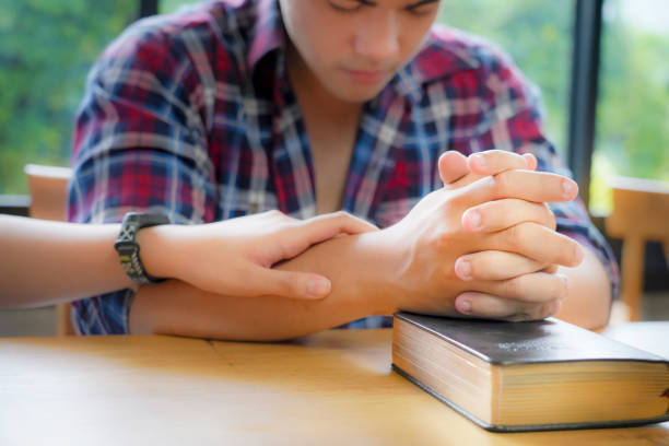 istock Christian Praying on open Bible. 1402772965