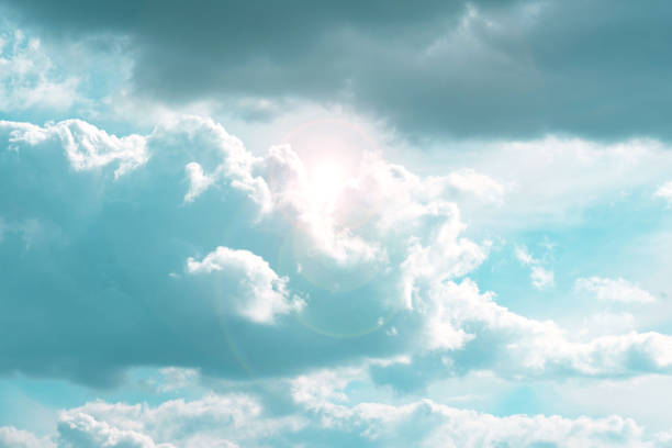 Sky.Clouds and sunshine. White clouds and sun rays in a light blue sky.Beautiful heavenly wallpaper in blue tones.sky is in very light pastel colors. Heaven background.