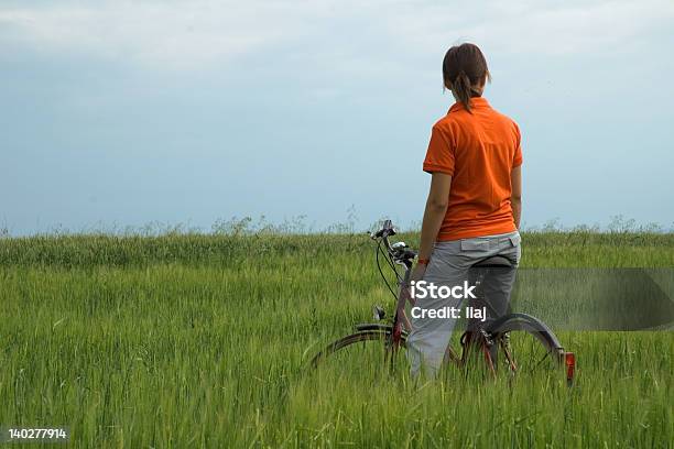Foto de Menina Sentada Na Bicicleta Em Campo Verde e mais fotos de stock de Adolescente - Adolescente, Adolescentes Meninas, Adulto