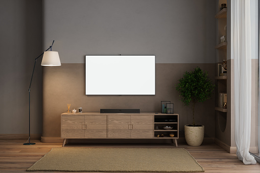 Sala de estar moderna por la noche con tv maqueta, gabinete, planta en maceta y lámpara de pie photo