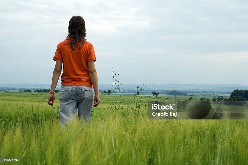 Chica caminando en campo con vista al valle - Foto de stock de Adolescente libre de derechos