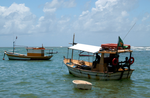 Brazilian fishermen in boats in blue green waters on a sunshine day