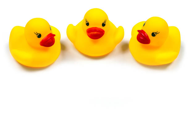 Ducklings on a white background. Three toy rubber ducklings close-up. Children's toy ducks.