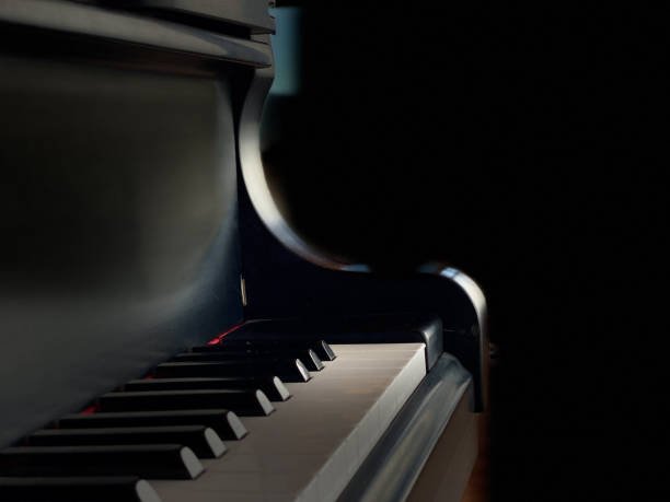 istock Piano with dramtic lighting on black background close-up 1402786624
