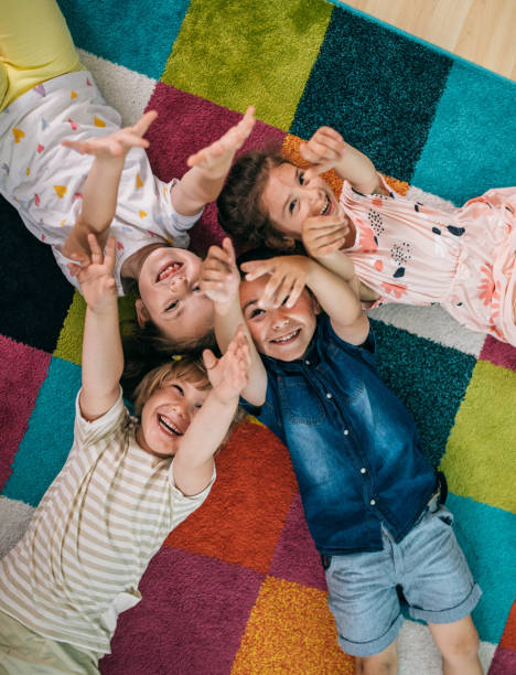 Smiling teacher and little child talking and playing at preschool Smiling teacher and little child talking and playing at preschool kid stock pictures, royalty-free photos & images