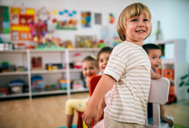 istock Smiling teacher and little child talking and playing at preschool 1402788198