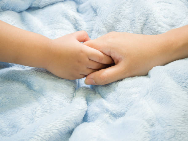 istock Baby hand gently holding adult's finger. 1402789297