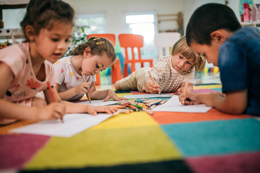 Group of preschoolers in art class painting pictures