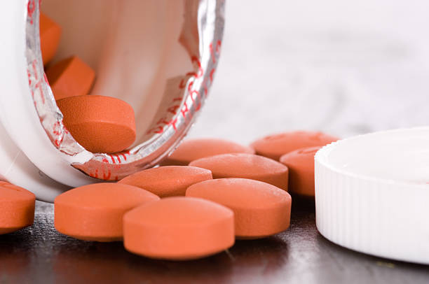Over the counter medication on black table with bottle and cap