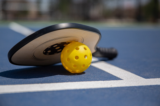 Top view of tennis racket with ball who lying on the surface of the court. Sport concept