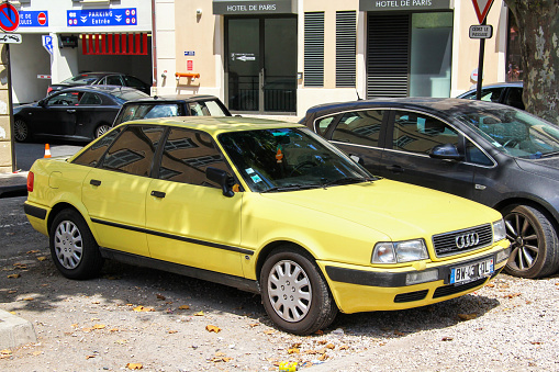 Saint-Tropez, France - August 3, 2014: Yellow compact sedan Audi 80 in a city street.