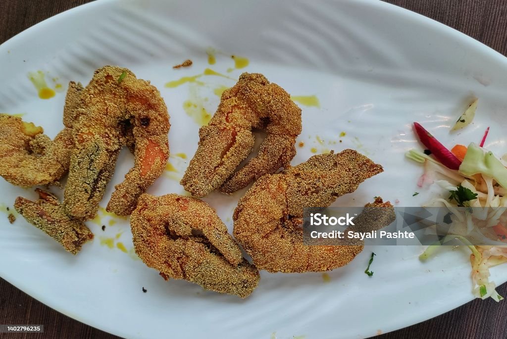 Fried prawns  in a plate with Lemon and coriander, famous food of Mumbai and coastal area of maharashta, India. Asia Stock Photo