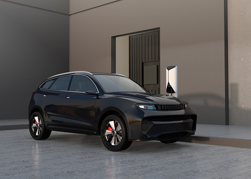Black electric SUV charing at home garage