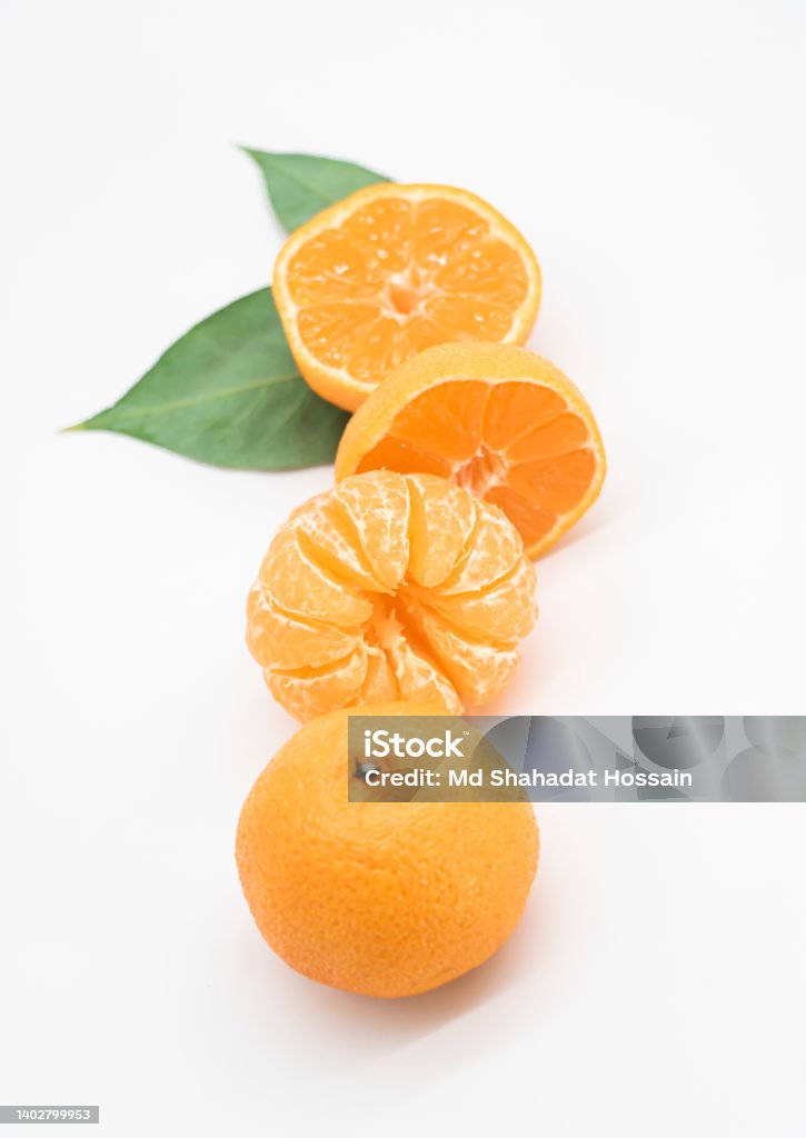 Tangerine or kamala pieces with green leaf over on white background Bangladesh Stock Photo
