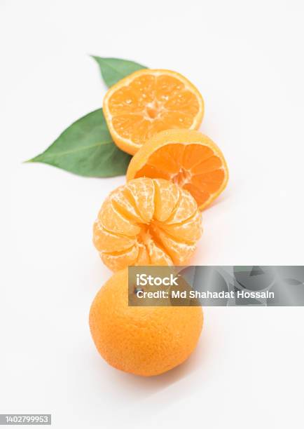 Tangerine Or Kamala Pieces With Green Leaf Over On White Background Stock Photo - Download Image Now