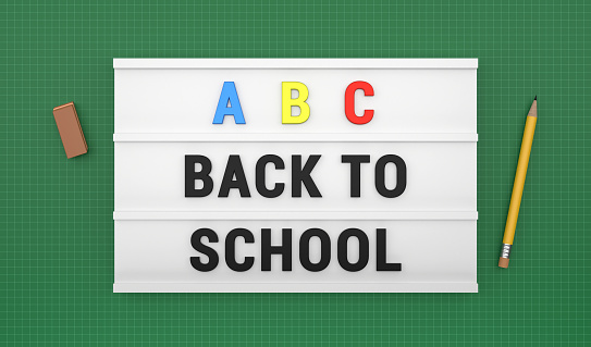 Back to School text and pencils on the lightbox is on a green background. Back to school concept.