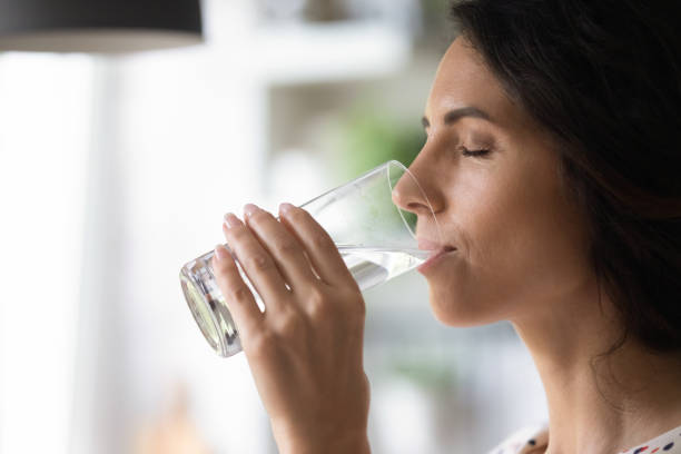 istock Peaceful woman satisfying thirst, drinking fresh pure clear cold water 1402803756