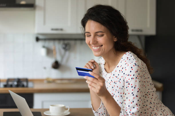 istock Happy female freelancer using credit card with low servicing cost 1402803764