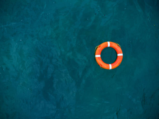 вид сверху на спасательный круг в море. спасательный круг, плавающий в море. - sos стоковые фото и изображения