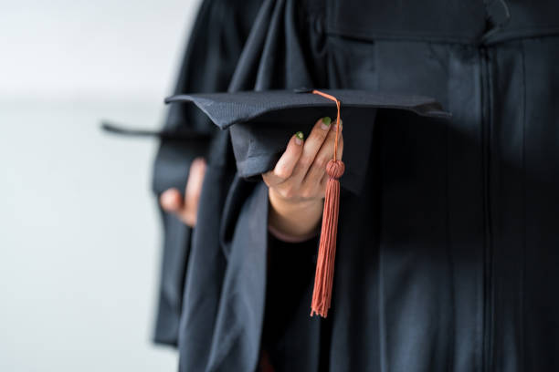istock Student holding graduation caps during commencement Graduation cap in the graduation ceremony. 1402809925