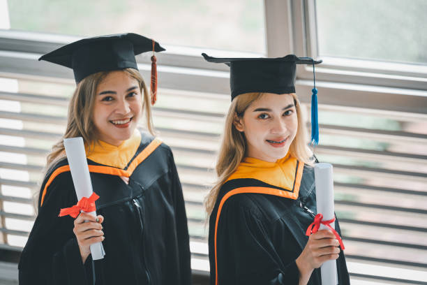 istock Student holding diploma degree certificate scroll during commencement Graduation graduation ceremony. 1402809928