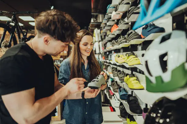 Photo of woman buying a cycling shoes in bike shop