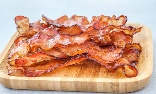 Bacon strips Fried bacon strips on the wooden plate cooked bacon slice stock pictures, royalty-free photos & images