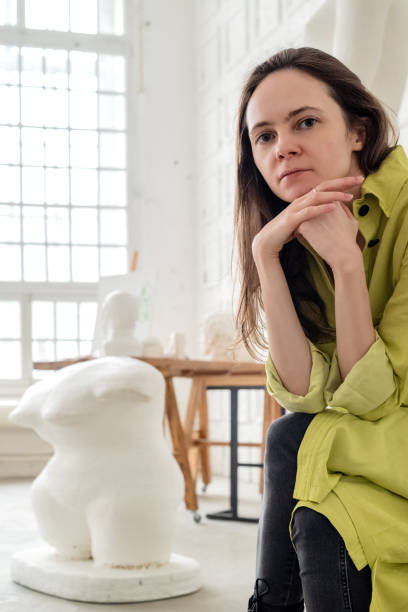 istock Female artist in art studio sits with her head on her hands 1402819824
