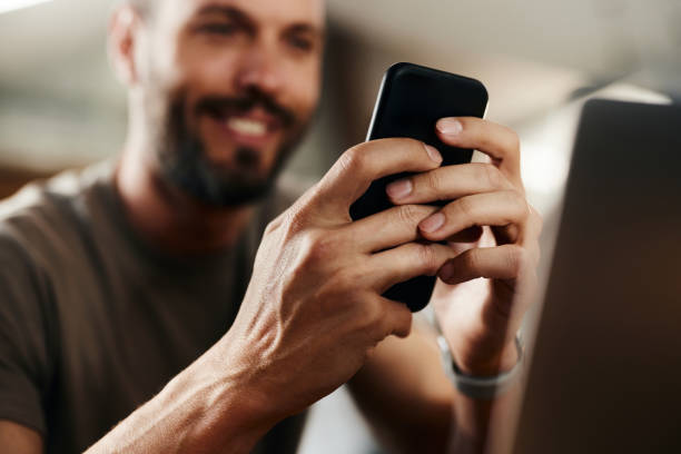 istock Close up of a man using cell phone at home. 1402820210