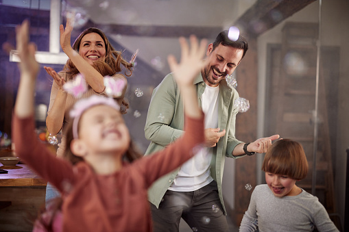 Young happy parents having fun while dancing on a party at home.