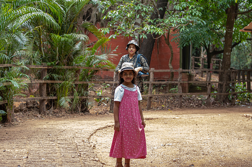 mother and 7 year old daughter walking around park in mangalore