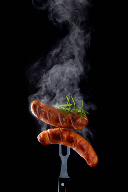 The grilled sausage with steam on the fork