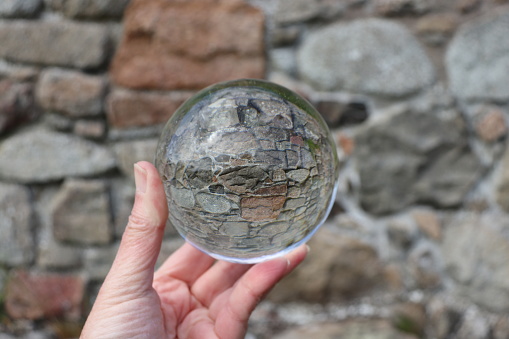 Old stone wall reflected in glass ball
