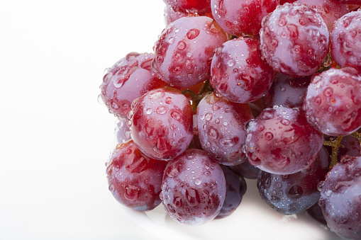 Fresh group of wet and clean fresh purple grapes on white
