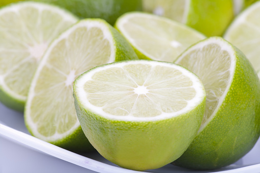 Ripe slice of green lime citrus fruit stand isolated on white background with clipping path