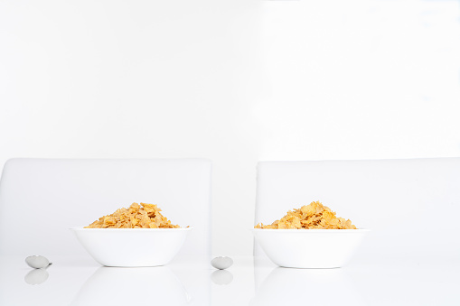 Couple of Morning plain Cornflakes cereal bowl on white dining room table