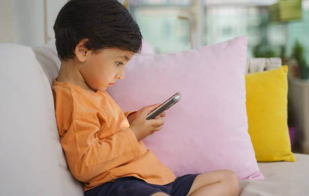 istock Cute toddler boy playing with a smartphone 1402827640