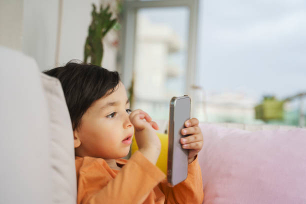 istock Cute toddler boy playing with a smartphone 1402827712