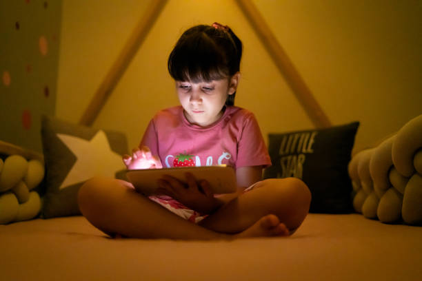 istock Little Girl Using Digital Tablet in Bed 1402828889