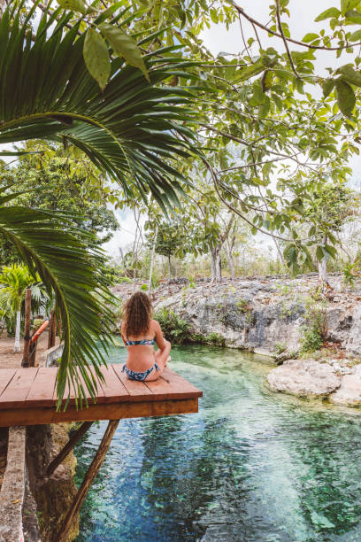 istock Woman sitting down meditating in Cenote, Mexico 1402830482