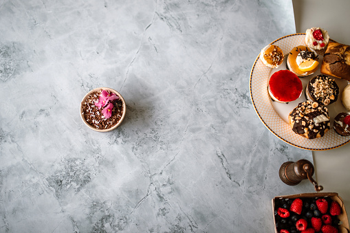 High angle view of delicious tiramisu on marble background, decorated with flowers