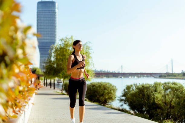 istock Young woman taking running exercise by the river promenade 1402833721