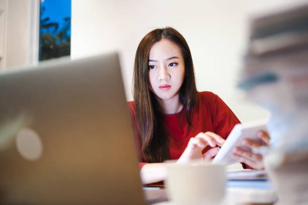 istock Female Accountant using a calculator during overtime at home at night. Workaholic people concept 1402840654