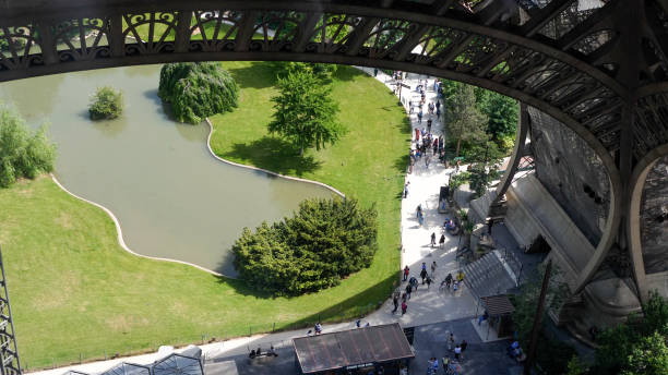 People walking under the Eiffel Tower, view from the first floor People walking under the Eiffel Tower, view from the first floor champ de mars stock pictures, royalty-free photos & images