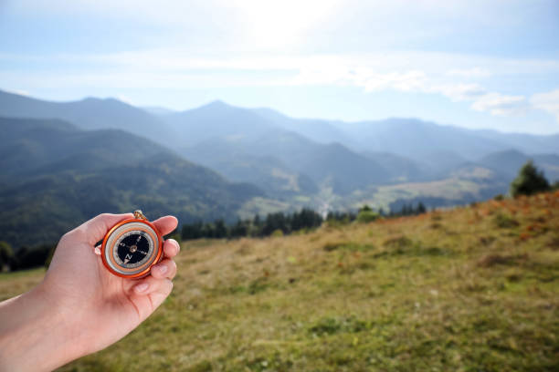 istock Woman using compass during journey in mountains, closeup 1402842036
