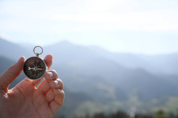 istock Woman using compass during journey in mountains, closeup 1402842037
