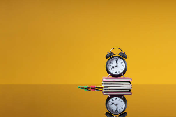istock School accessories as a back to school concept. Alarm clock on a stack of books and colored brushes as a background with free space for the website of a school, institute, university, an article about school education 1402843378