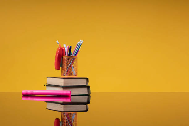 istock School accessories as a back to school concept. Writing materials on a stack of old books and a pink marker as a background with free space for the website of the school, institute, university, article about school education 1402843861